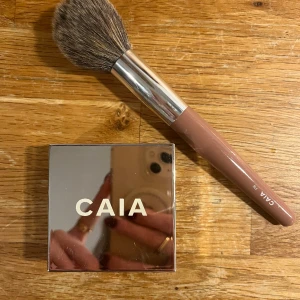 Caia puder och borste  - Caia loose setting powder i färg Honey, använd men mer än hälften kvar  Borste F16, knappt använd  