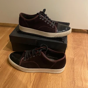 Vinröda Lanvins storlek 43/44 - Hej, säljer nu mina vinröda lanvins då de var för stora för mig. Nypris cirka 4500kr, mitt pris 2200kr. Bra skick inga defekter eller skador. Dustbag, skolåda, samt extra skosnören kommer med