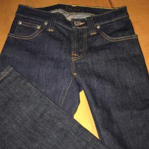 Riktigt fina jeans i mörkblå tvätt med oranga sömmar, som ny. Smala ben.