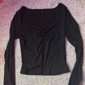 En svart topp/tröja med spets och en liten ihopdragning vid bysten. Inga defekter, använd ca4gånger. Säljer då har blivit för liten.