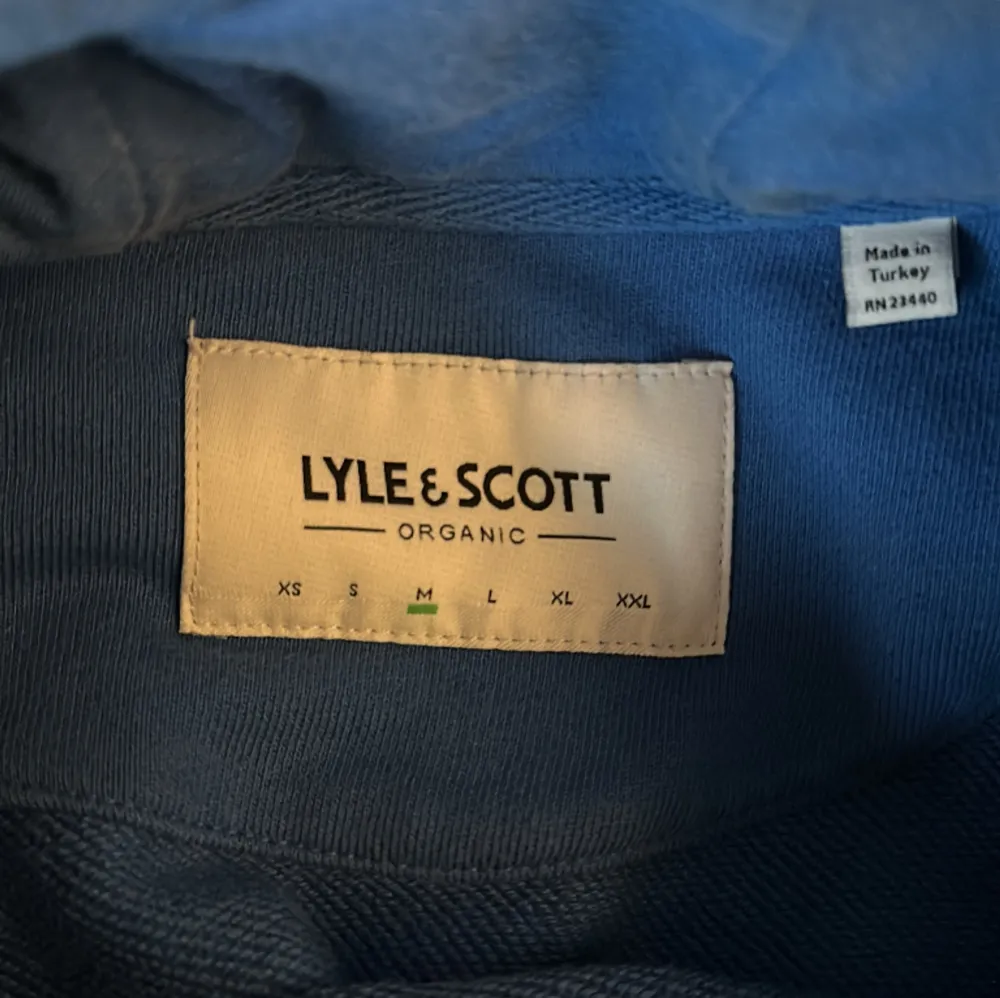 En blå hoodie av märket Lyle & Scott. Storlek M men passar lika bra på någon som har S. Pris 200kr.. Hoodies.
