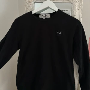 COMME DES GARÇONS PLAY tröja  - Säljer min fina långärmade CDG tröja i svart i strl M. Använd men i mycket bra skick. Liten i storlek, passar mig som är en dam S. 