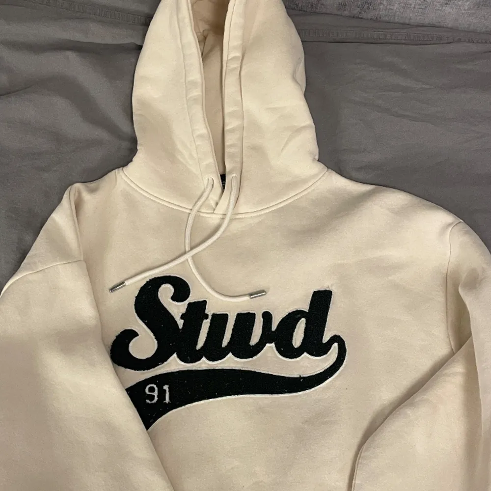 Cremevit hoodie med broderat tryck, köpt från Pull&Bear. Hoodien är i gott skick, bara lite nopprig vid trycket (se bild 2). Köptes för 399kr . Hoodies.