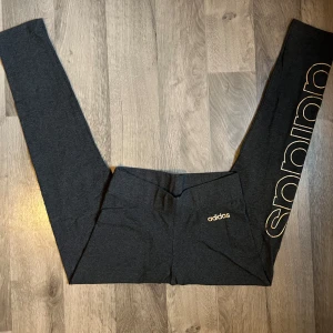 Adidas tights storlek S - Ett par mjuka mörkgråa adidas tights i storlek S. Använda några gånger. Sitter supersnyggt och är väldigt bekväma! Ett märke på sidan av benet i ”guldig” text