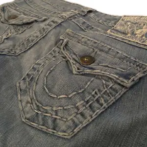 Ett par jeans från true religion i superfint skick! Mått tvärs över midjan är 36cm, mått tvärs över låret är 22cm, mått tvärs över smalbenet är 18cm och innerbenslängden är 75cm💗skulle säga att dom är lite bootcut också! Kontakta gärna via frågor💞