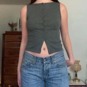 Grå topp - Linne/topp med knappar framtill och hög båtringad hals, från Asos! Köpt för ca 300 kr och är aldrig använd 🤍