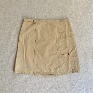 Diesel-kjol - Kort beige cargokjol som knäpps med knapp och kardborre i midjan, vintage Diesel! Midjemåttet är 66 cm och längden 38 cm (för liten på mig) 🩷