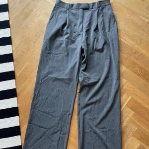 Kostymbyxor Djerf Avenue - Gråa kostymbyxor från Djerf Avenue i storlek M. 🩶 Fint skick då dem endast är använda fåtal gånger. Ger en väldigt ”clean look”. Nypris 1499:-