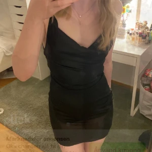 Kort svart klänning med snörning  - Klänning med snörning i ryggen. Så fin för finare tillfällen eller fest. Knappt använd.