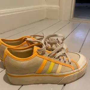 Jag säljer ett par super snygga adidas skor som är i beige färg med orangea detaljer, har bara avnänt de fåtal gånger men de är lite smutsiga bara. 