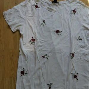 T-shirt med blommor - Vit t-shirt med sydda blommor. Storlek S, använt men fint skick. Hämtning, annars betalas frakt av köparen. Bara att skriva vid frågor eller bud! 🌻 