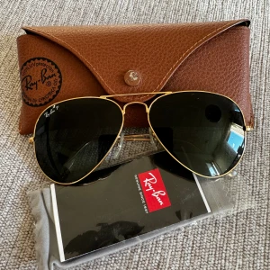 Ray Ban aviator large metal rb3025 - 001/58 polariserade - Säljer solglasögon från Ray Ban i nyskick med alla originala tillbehör (se bild). Polaiserade.  Modell: aviator large metal rb3025 - 001/58 Bågfärg: guld Glasfärg: mörkgrön Bågmaterial: metall  Mått: Glasbredd 58 mm (M)  Näsbryggans bredd 14 mm Skalm