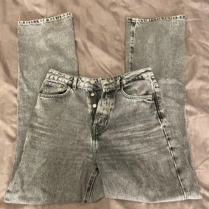Gråa jeans  - Gråa fina jeans från Gina tricot. Dom är normala i storleken och storleken är 27/32. Dom ör högmidjade och något vida vid benen. Dom är inte använda särskilt mycket. Nypris 499.