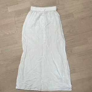 Vit maxikjol linne  - Vit maxikjol i linne från HM, har slitsar på båda sidorna. Tyvärr lite missfärgad, därav billigt pris! Går säkert att få bort till viss del med lite ansträngning! 