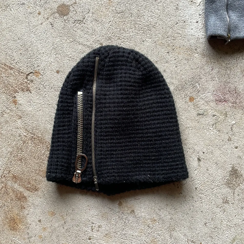 Upcycles beanies featuring zippers and graphics. Accessoarer.