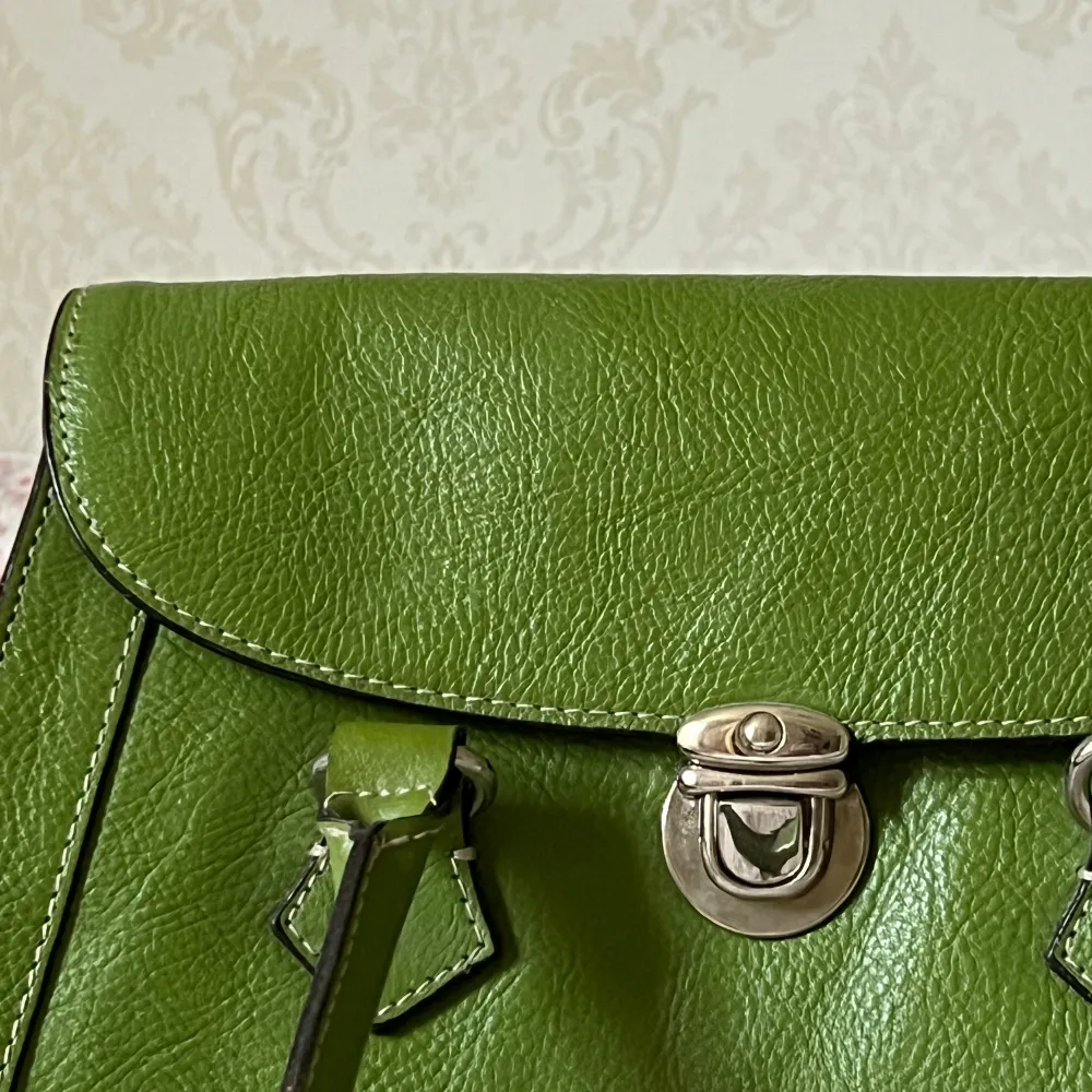 Grön väska köpt second hand i England!💚Den har ett fack med dragkedja och två små andra fack inuti. Har aldrig använt den och väskan är i mycket bra skick! Måtten är 28x20x10. Väskor.