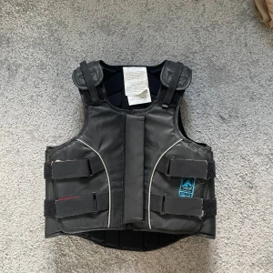 Ridväst - Säkerhetsväst: Level 3  Nypris: runt 1000 Skick: Använd sparsamt och har aldrig ramlat av med den.  Finns defekter (kolla sista bild), av servetter jag torkat den med. Syns knappast. 9-13 år 