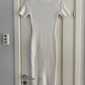 vit stickad ribbad klänning i strl 38 fr Missguide - vit stickad ribbad klänning i strl 38 fr Missguided.  Endast använd en gång och är i väldigt fint begagnat skick.  Mått Över bröstet: ca 40 cm Längd från axeln och ner: ca 112 cm  70% viskos och 30% polyamid  Kommer från ett djur och rökfritt hem.