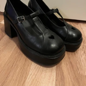 svarta mary jane skor - ♡ super fina mary-jane skor med ett hjärta som är ihåligt, visar en del av ens strumpor! ♡ använt ett fåtal gånger ♡ vegansk läder  ♡ 7,5 cm klackhöjd ♡ storlek 37