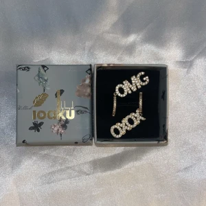 ioaku örhängen  - Säljer mina örhängen från ioaku för endast 250 kr i guld, på ena örhänget står det OMG och det andra XOXO med diamanter💗 original pris 600kr och man får med lådan till örhängena, kom gärna privat för fler frågor/bilder