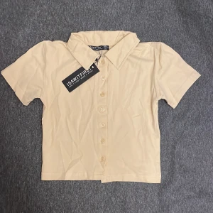 topp knappad  - En kanppad  t-shirt topp , croppad,  fin färg  Helt ny ! Perfekt till sommaren 