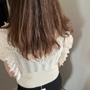 Virkad topp med volang  - Bra skick, knappt använd. Virkad topp med volang på ärmen, kortare i modell.