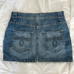 Jeanskjol - Jeanskjol från H&M. Stl 40 passar bra på stl 38 ifall man vill ha den lågmidjad vid höfterna. För liten för mig därav säljer jag den.