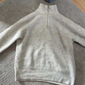 Zipup tröja från HM - Beige stickad halvzip tröja från HM, bra skick men lite nopprig. Storlek S.