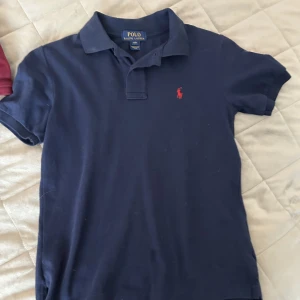 Polo tröjor - En vin röd i strl 10-12 och en marin blå i strl 8