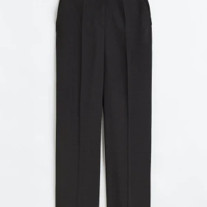 Dressad byxa från H&M - Nya svarta glansiga kostymbyxor. Storlek 34 med prislappen kvar.