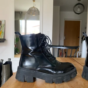 Svarta boots - Glansiga svarta kängor. Sköna och i gott skick förutom små skrapmärken vid tårna som bilden visar. Storlek 38.