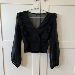 Svart blus - Fin blus med volanger i nyskick. Materialet är lite genomskinligt. Storlek S men passar även Xs. Köparen står för frakt💗