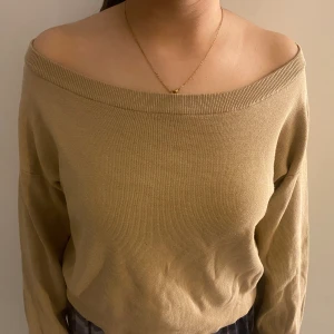 Off/one shoulder tröja i tjockt material  - Tröjan är i en beigeaktig färg med ett tjockt material som passar både hösten och vintern. Tröjan är i storlek M men passar alla mellan storlekarna Xs-M då den är stretchig och har en passform som inte ser stor ut. 