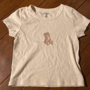 T-shirt köpt på Brandy Melville One size ca Xs. Fint skick, minimal fläck ovanför björnen som syns på andra bilden. 