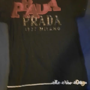 T-shirt  - En fin tshirt som har märket prada på men är inte en äkta.