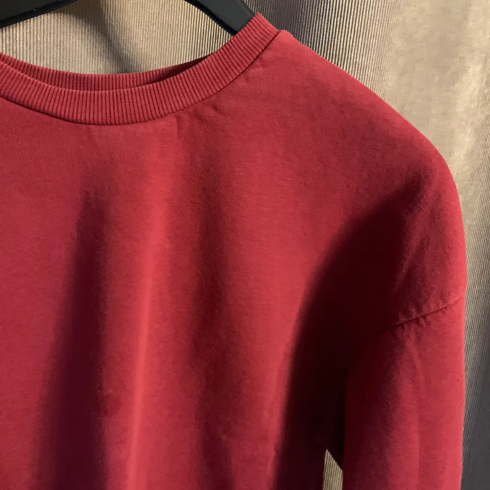 En vanlig tjocktröja med en jättefin röd färg! Tyvärr är det en liten fläck som ej går bort men generellt är tröjan i bra skick! . Tröjor & Koftor.