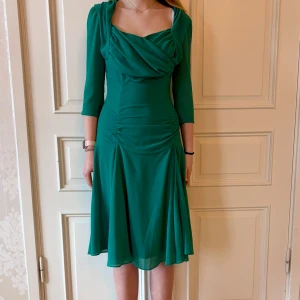 Grön klänning, Emmy Design - Jättefin grön klänning i skönt, stretchigt material. Storlek 38. Ärmarna är lite genomskinliga Modellen på bilden är 173 cm och har storlek 38 i de flesta andra kläder. Aldrig använd. Vi har lagt ner vår klänningsbutik och säljer ut. Ny pris är 2000-