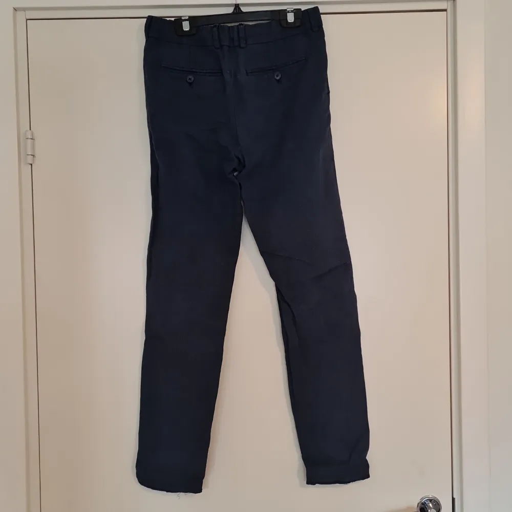 Marinblå Chinos från H&M. Linnebyxor, väl använda. Storlek: 164 (XXS) Follen längst ner är utvikt. . Jeans & Byxor.