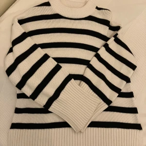 Stickad tröja Strl XS - Ribbstickad vit/marinblårandig tröja i bomull/akryl från Gina Tricot i lite längre modell (XS men rymlig i storleken). 