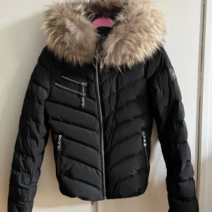 Hollies jacka - Hollies ”Chatel” jacka med fina silver detaljer i storlek 32. Säljes då den inte längre kommer till användning. Använd men väl omhändertagen så skulle säga att den är i nyskick. Äkta päls. Köpt för 4000kr på SALT. Lappar finns.