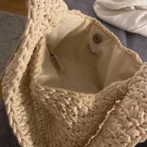  Stickad väska  - Heej, säljer min beigea stickade väska från weekday. Inköpt förra våren och har använts ungefär 5 gånger. Den är i bra skick förutom att den har lite defekter, det är ju en vit/beige väska så lite svårt att undvika:) Det är bara att höra av vid frågo