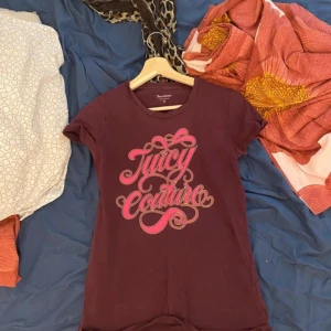 juicy t-shirt. - Fin juicy t-shirt, har inge defekter som jag kan se. Har haft den i strax ett år men den är ärvd vilket innebär att den är gammal. färgen är inte riktigt röd men inte riktigt rosa eller lila heller....men det är en vacker kombination.