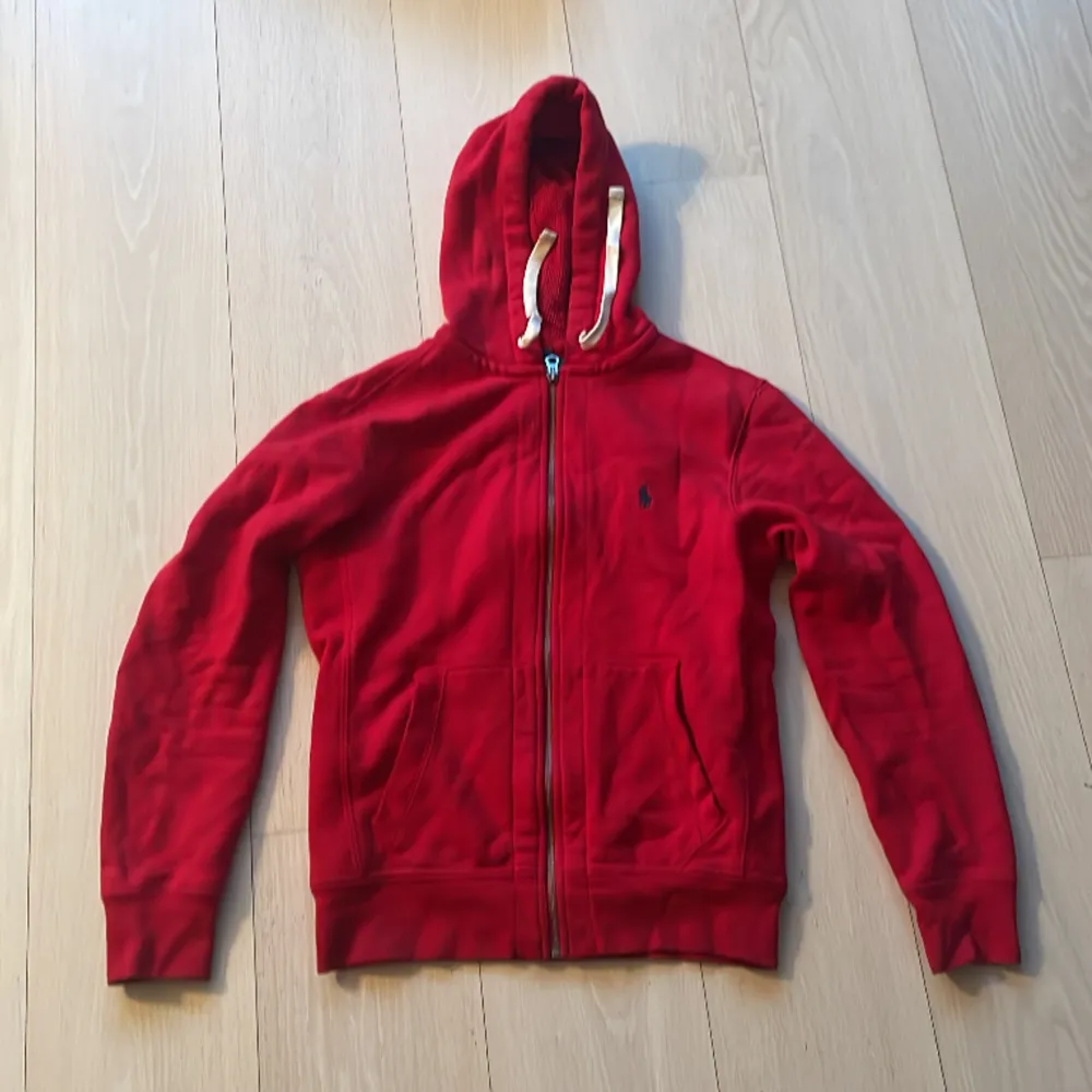 Tjena jag säljer en röd polo Ralph lauren zip hoodie i storlek S🧣 tröjan är i perfekt skick utan några fläckar eller hål🌹hör av er vid frågor❤️. Hoodies.