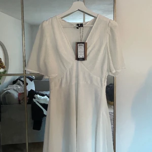 Vit klänning  - Vit klänning med djup v ringning. Jätte fin men kommer inte till användning, prislappen sitter kvar på plagget. Den är väldigt sommrig och passar bra till studenten.💕💕