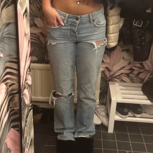 Ljusblåa low waist jeans med hål🩵 - Älskar dessa😍 Har klippt liten slit ner till så de sitter bättre med skor! Det finns även inga framfickor(man kan inte lägga något i dom),men de är inget som syns eller man själv tänker på!💗 Midjemåttet rakt över är 36cm och innerbenslängden är 82cm🫶🏼