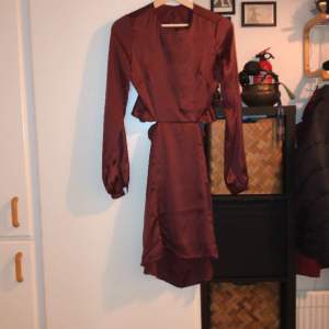 Vinröd, öppenryggad klänning med långa ärmar 