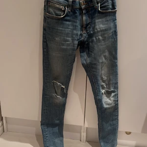 Nudie jeans - Snygga nudie jeans med fina slitningar. Jeansen är i bra skick och har inga defekter. Skriv vid funderingar.