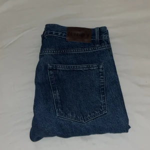 NN07 Straight Jeans - Riktigt sköna & mörkblåa jeans från No Nationality. Modell Sonny 1816 Sttsight leg jeans. Nypris 1800kr. Använda men inga synliga tecken eller skador. Mått: Midja: 44cm Längd: 104 Innerbenlängd: 77cm Benvidd 21cm
