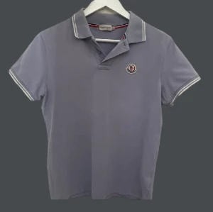 Moncler polo/pike - Tja! Säljer en snygg Moncler Piké.   Skick 8/10, litet hål vid armen.  Passar dig som är ca 170-175cm. Har fler bilder så tveka inte på o höra av dig!  Mvh Odin
