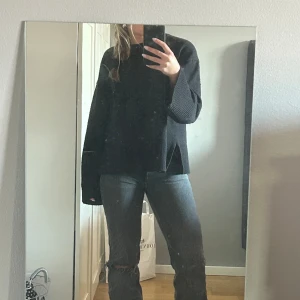 Gråa jeans  - Säljer ett par superfina jeans från Gina tricot. Dom är i storlek 34. Jeansen är i bra skick och har ett hål i vänster knä. Längst nere är det slitet vilket är en del av modellen. 